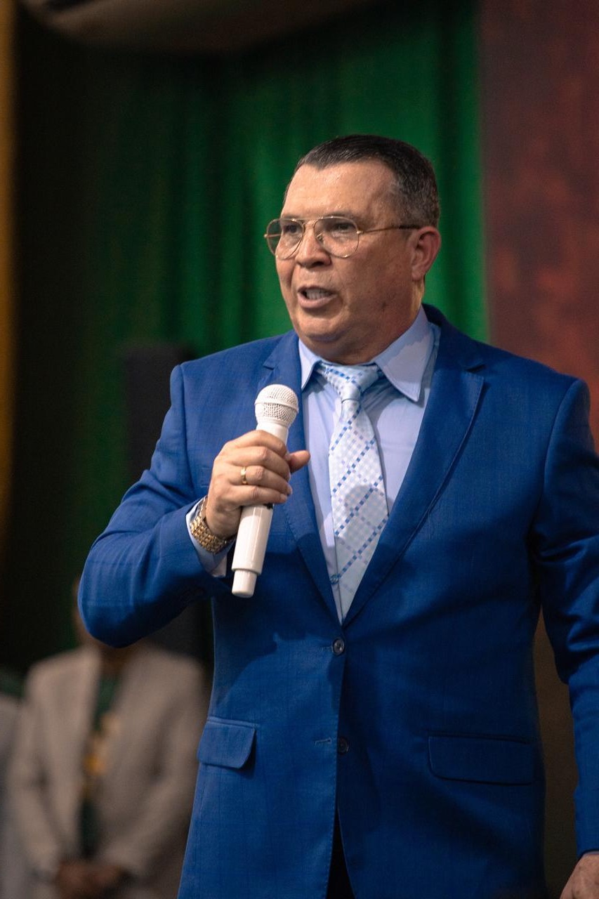 Pastor Cláudio Gama pregando ao microfone